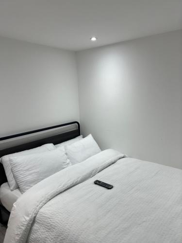a remote control sitting on top of a bed at QB Stylish 2 Bedroom Apartment - Smart TV - Wifi - Parking in West Thurrock