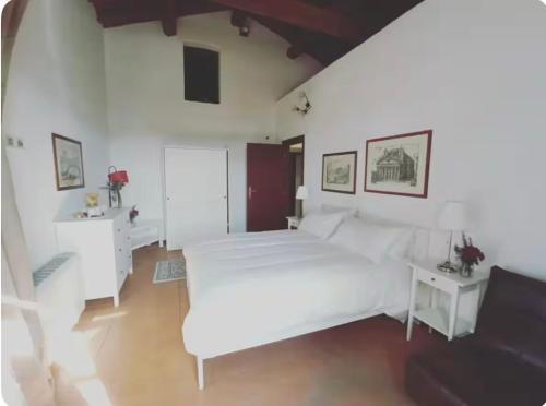 a white bedroom with a white bed and a desk at Casale Traiano in Fiumicino