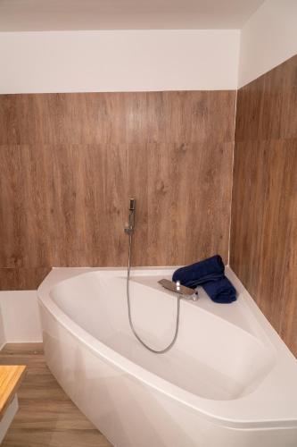 a white bath tub in a bathroom with wooden floors at Appartement campagne in Moulins