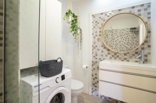 y baño con lavadora, secadora y espejo. en Apartment in Los Cristianos by the beach, en Los Cristianos