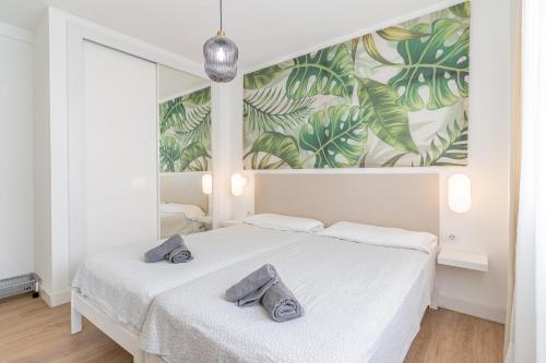 Un dormitorio con una cama blanca con toallas. en Apartment in Los Cristianos by the beach, en Los Cristianos