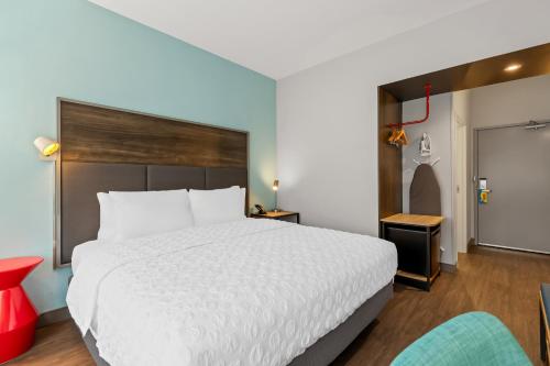 a bedroom with a white bed and a red chair at Tru By Hilton Aloha Beaverton in Beaverton