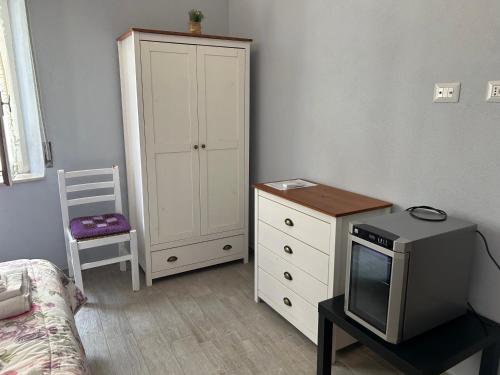 a bedroom with a dresser and a cabinet and a television at B&B Babay in Guspini