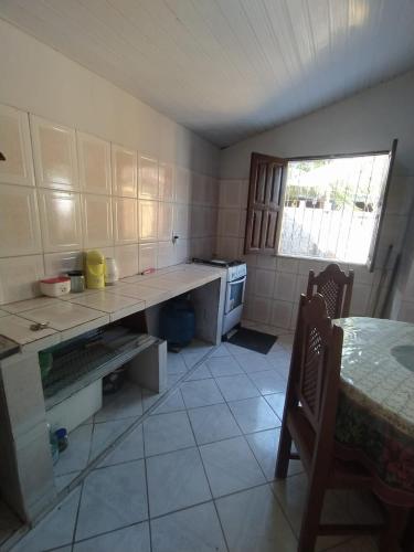 a kitchen with a counter and a table and a window at La Fortaleza Algodoal in Maracanã