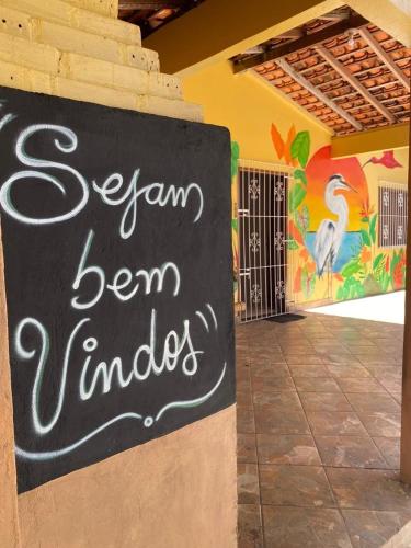 a sign on the side of a building with a mural at La Fortaleza Algodoal in Maracanã