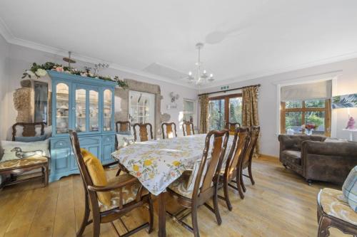 a dining room with a table and a blue cabinet at The Strone Luss Premium Holiday Rental in Luss