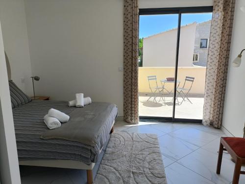 - une chambre avec un lit et une vue sur une terrasse dans l'établissement La Villa du Sud, Arles Camargue, à Arles