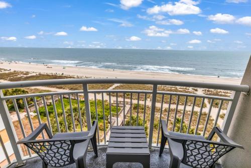 Un balcón con mesa y sillas y la playa. en Atlantica 601, en Myrtle Beach