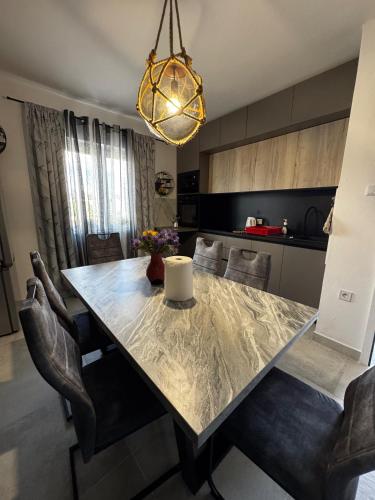 a dining room table with chairs and a light fixture at Apartman Nonno Božo 2 in Fažana
