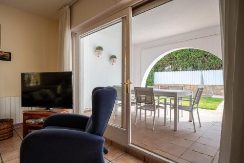 un soggiorno con tavolo, sedie e porta scorrevole in vetro di At503 Ground floor & pool, beach 15min walk away a Comarruga