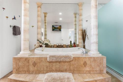 eine Badewanne im Bad mit Säulen in der Unterkunft Villa Estelle - Huge lake front Villa in Cape Coral