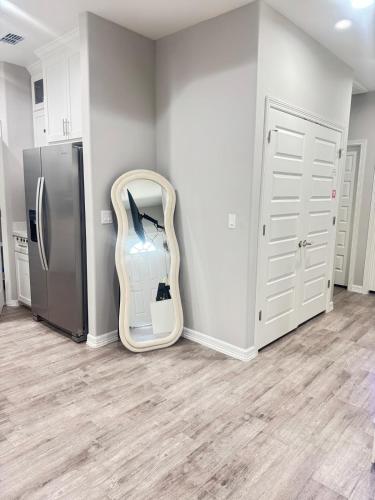 a room with a refrigerator and a mirror in the corner at Premier Luxe Villa in Weslaco