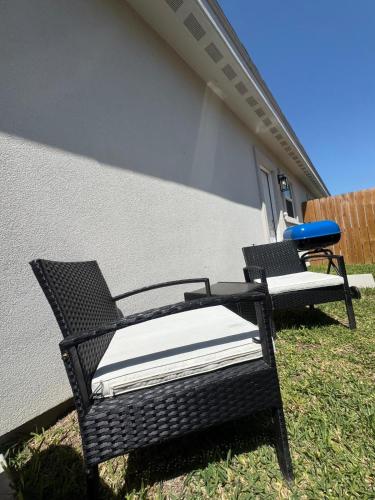 two chairs sitting in the grass next to a building at Premier Luxe Villa in Weslaco