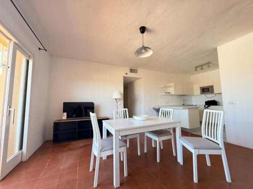 a kitchen and dining room with a white table and chairs at Dimora Lombardi Portocervo in Porto Cervo