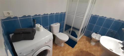 baño azul con lavadora y lavamanos en Las Americas Holiday Studio, en Adeje