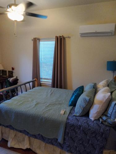 a bedroom with a bed with pillows and a fan at Panoramic View Canyon Lake Home in Canyon Lake
