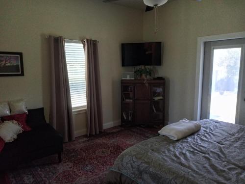 a bedroom with a bed and a tv and a chair at Panoramic View Canyon Lake Home in Canyon Lake
