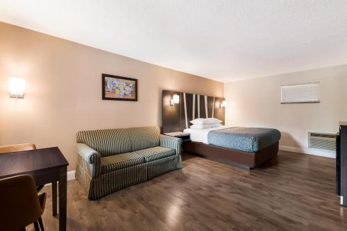 a hotel room with a bed and a chair at Econo Lodge Inn & Suites on the River in Gatlinburg