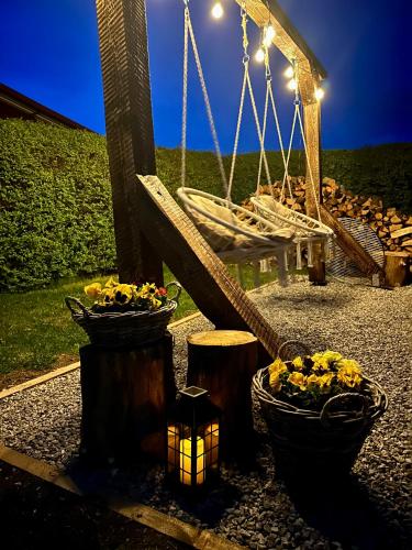 a swing with flowers in pots and a light at Apartmán Ranč in Martin