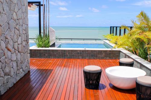 a deck with a bath tub and the ocean at Ocean Art Park - By Living in João Pessoa