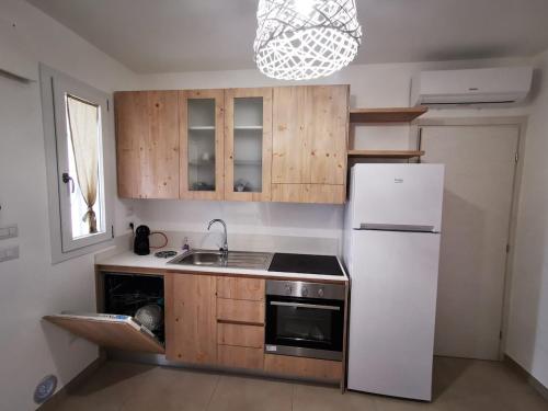 Una cocina con refrigerador blanco y gabinetes de madera. en Borgo Celentano, en Torre Lapillo