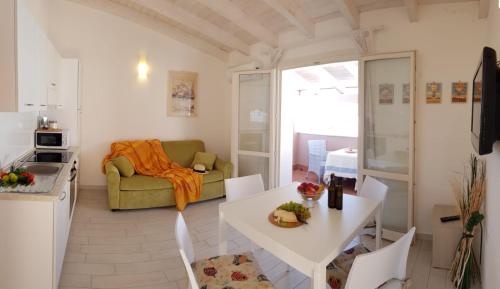 a kitchen and living room with a table and a couch at Affaccio sul Golfo dell'Asinara in Badesi
