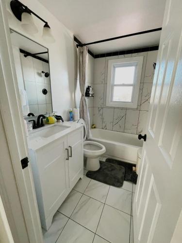 a white bathroom with a sink and a toilet at Cozy Roomy family sized apartment on major bus route close to all in Orchard Park