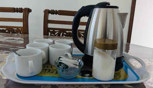 a coffee maker on a tray with cups on a table at Cozy home in Badulla