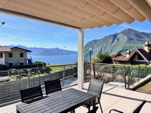 a porch with a wooden bench and a view of the mountains at Costa Blu - Pool & terrace lake view in Riva di Solto