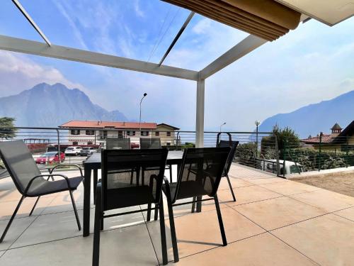 a table and chairs on a balcony with a view of a mountain at Costa Blu - Pool & terrace lake view in Riva di Solto