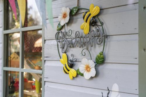 a sign on the side of a house with flowers at The Strone Luss Premium Holiday Rental in Luss