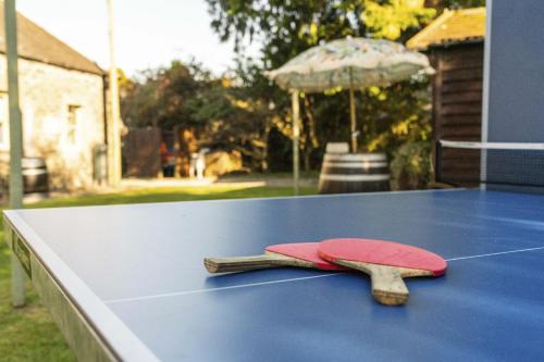 a ping pong table with a red paddle on it at The Strone Luss Premium Holiday Rental in Luss