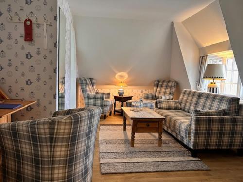 a living room with two couches and a table at Boutiquehotel Seiler Hof Keitum in Keitum