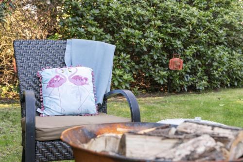 a chair with a pillow sitting next to a fire at The Strone Luss Premium Holiday Rental in Luss