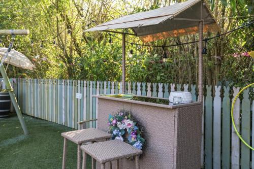 a garden bar with two chairs and an umbrella at The Strone Luss Premium Holiday Rental in Luss