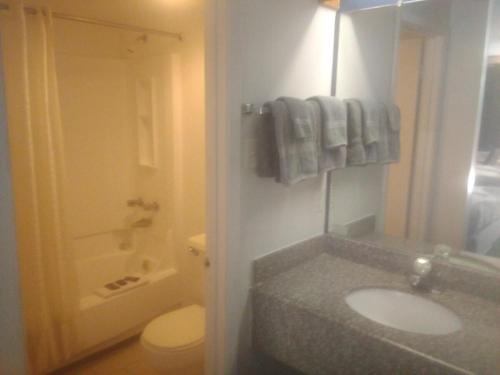 a bathroom with a sink and a toilet and towels at King Bed Hotel Studio 102 in Livingston