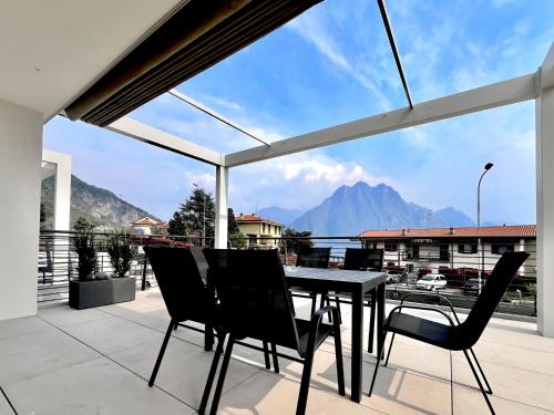 a table and chairs on a balcony with a view of a mountain at Costa Blu - Pool & terrace lake view in Riva di Solto