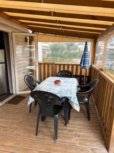 un patio avec une table et des chaises sur une terrasse dans l'établissement Lège-Cap-Ferret, confort et activités à 6 by Vayny, à Lège-Cap-Ferret