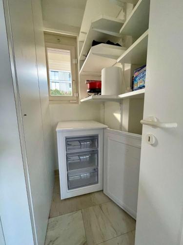 a small kitchen with white cabinets and a refrigerator at Spacious house with partial lake view in Luzern