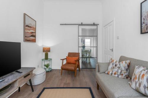 a living room with a couch and a tv at Appin House -Cosy 2 bed house in Dunfermline in Dunfermline