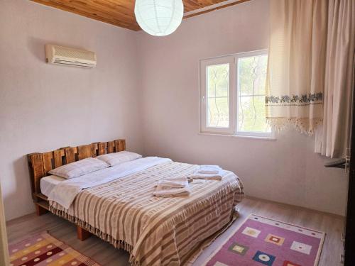 a bedroom with a bed and a window at Olympos Orange Village Nature, Sea and You in Kumluca