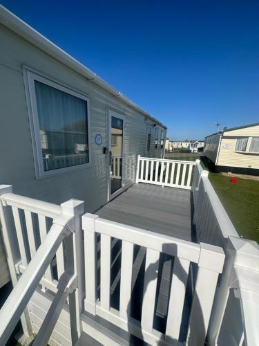 a deck with a white railing and a house at 8 Birth Holiday Home in Selsey