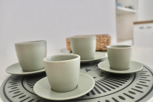 four cups and saucers sitting on a table at Ringo Suites in Grumo Appula