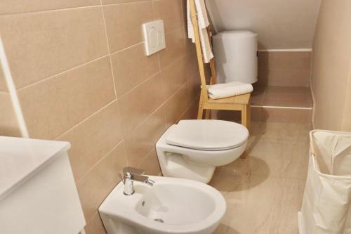 a bathroom with a white toilet and a sink at Ringo Suites in Grumo Appula