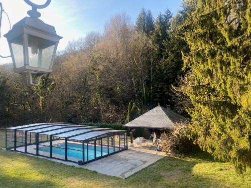 a gazebo with a pool and a street light at LE CLOS DU TULIPIER in La Chapelle-du-Bard