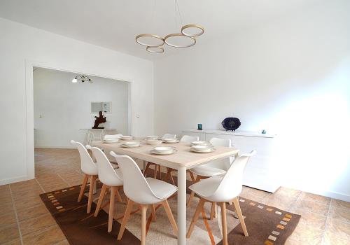 a white dining room with a table and white chairs at GALIHOST - Mirando al Mar in Isla de Arosa
