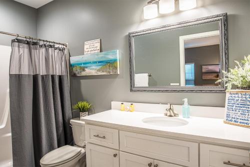 巴拿马城海滩Beach Daze的带水槽、马桶和镜子的浴室