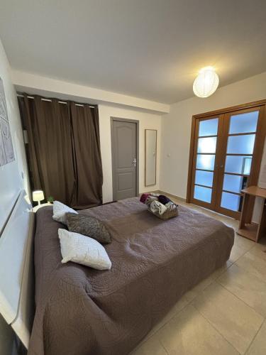 une chambre avec un grand lit avec des oreillers dessus dans l'établissement Appartement Romana PUISSALICON 34, à Puissalicon