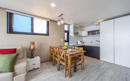 a living room with a dining room table and a kitchen at Soleiview Spa Pension and Resort in Buan
