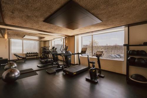 a gym with several exercise equipment and a large window at Maison Heler Metz, Curio Collection By Hilton in Metz